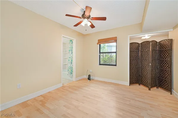 a view of empty room with wooden floor and fan