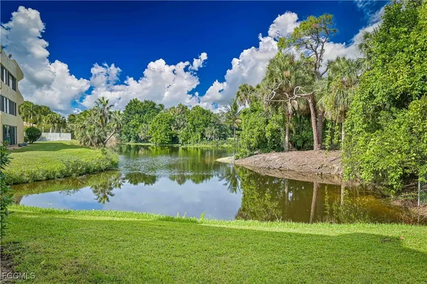 a view of a house with a yard and a fountain