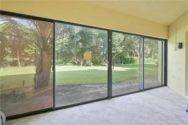 a view of backyard with large windows and swimming pool