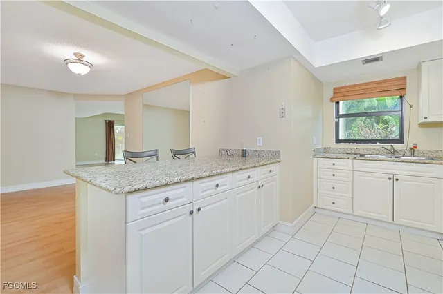 a spacious bathroom with a granite countertop sink and a mirror