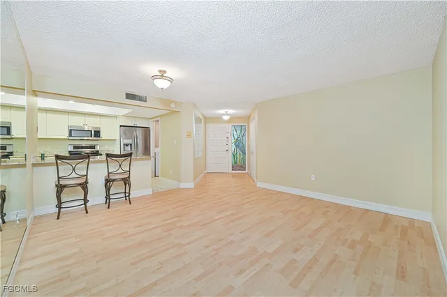 a view of kitchen with refrigerator stove and wooden cabinets