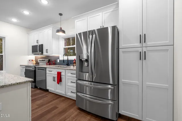 a kitchen with stainless steel appliances a refrigerator and a stove top oven