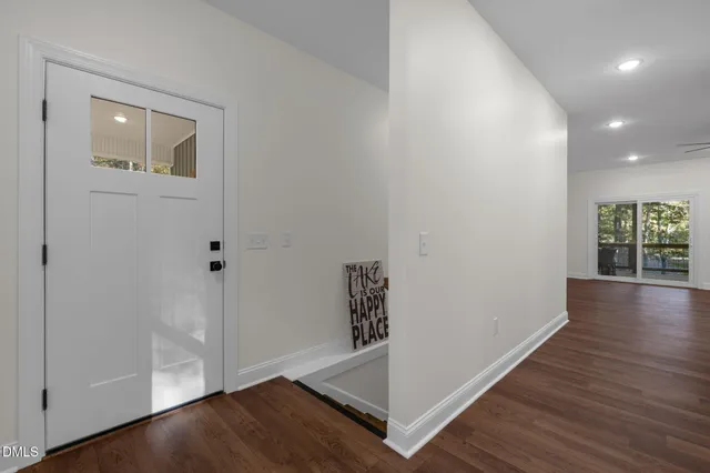 an empty room with wooden floor and entryway