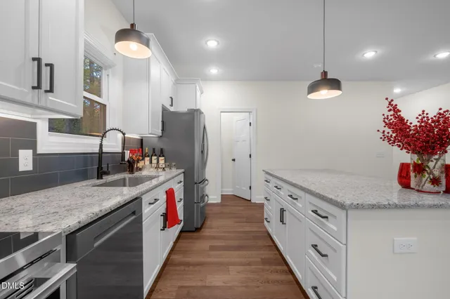 a kitchen with stainless steel appliances granite countertop a sink and a stove