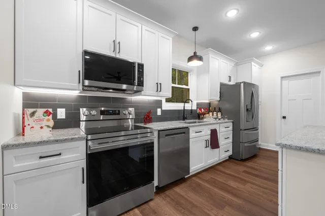 a kitchen with stainless steel appliances a stove microwave and a refrigerator