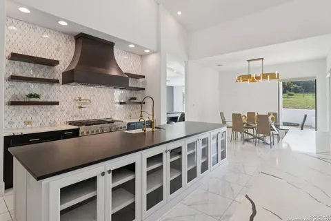 a kitchen with stainless steel appliances kitchen island granite countertop a sink and a stove