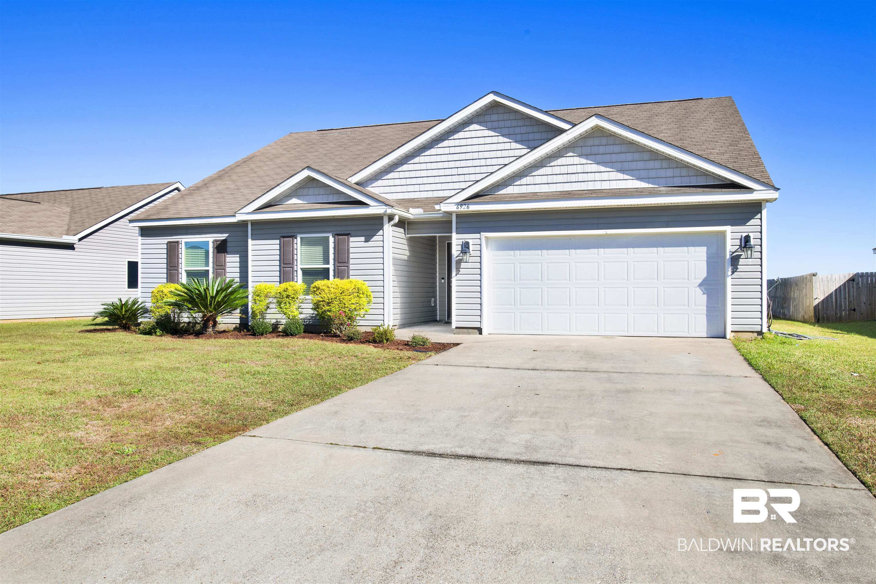 6926 Crimson Ridge Street Gulf Shores, AL 36542 - Photo 1 of 18 View of front of house with a front lawn, concrete driveway, and a garage