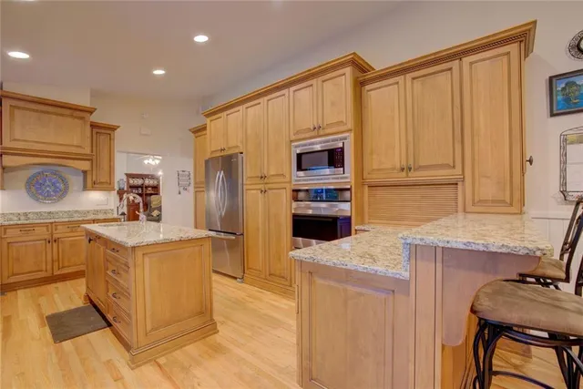 a kitchen with stainless steel appliances granite countertop a refrigerator and a stove top oven