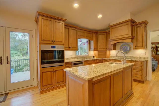 a large kitchen with stainless steel appliances granite countertop a refrigerator and a sink