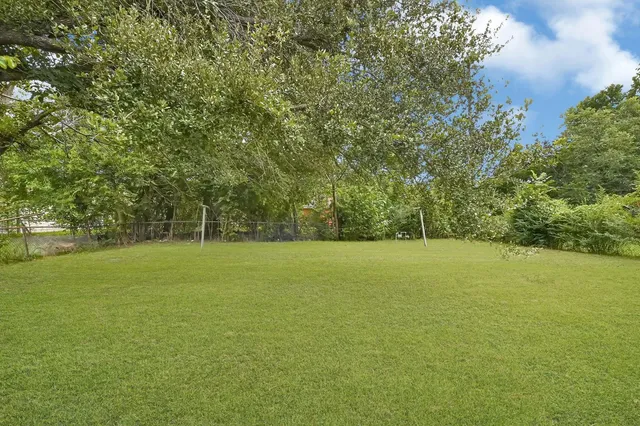 a view of a field with trees in background