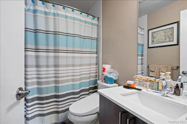a bathroom with a sink a toilet and shower curtain