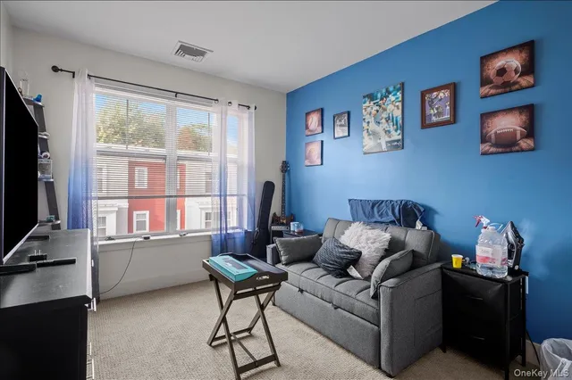 a living room with furniture a window and a flat screen tv