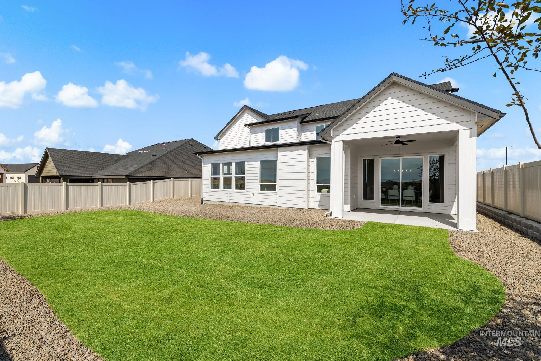 345 South Strut Way Boise, ID 83716 - Photo 49 of 50 Expansive backyard featuring a manicured lawn, gravel perimeter, covered patio, sliding glass door access, and a privacy fence