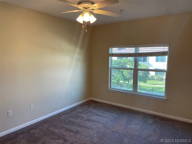an empty room with a window and a fan