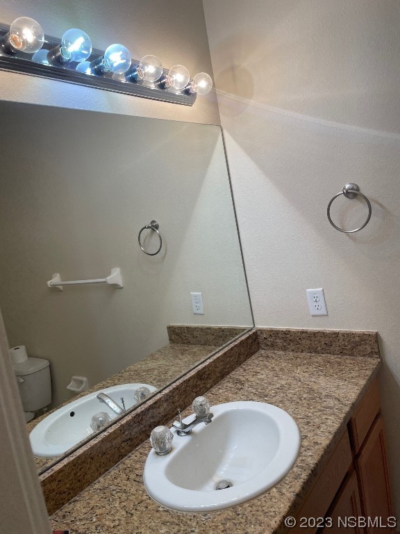 Undisclosed Address New Smyrna Beach, FL 32169 - Photo 13 of 22 a bathroom with a granite countertop sink and a mirror