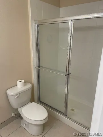 a white toilet sitting next to a shower