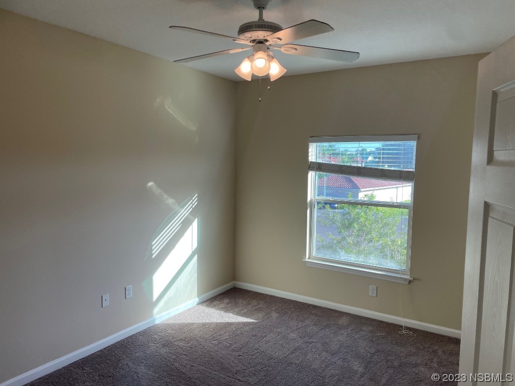 Undisclosed Address New Smyrna Beach, FL 32169 - Photo 7 of 22 a view of an empty room with window and chandelier fan