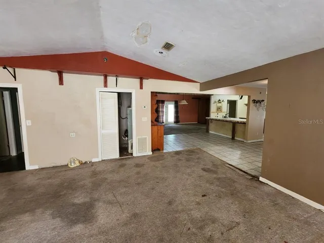 a view of a hallway with a dining table and chairs