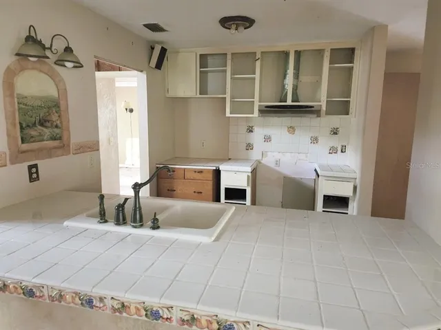 a large bedroom with a bed and a view of living room