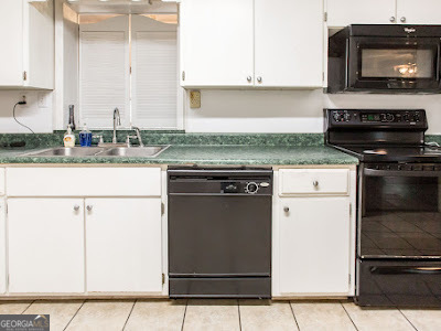 5209 Highway 32 Patterson, GA 31557 - Photo 20 of 45 a kitchen with granite countertop a stove top oven cabinetry a sink and a microwave