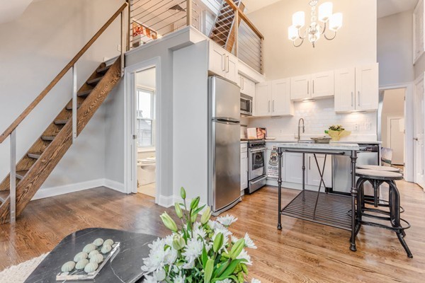 80 Rutland Street, Unit 3 Boston, MA 02118 - Photo 17 of 26 a living room with furniture and a dining table with wooden floor