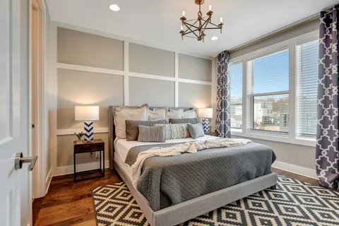 a bedroom with a large bed and windows