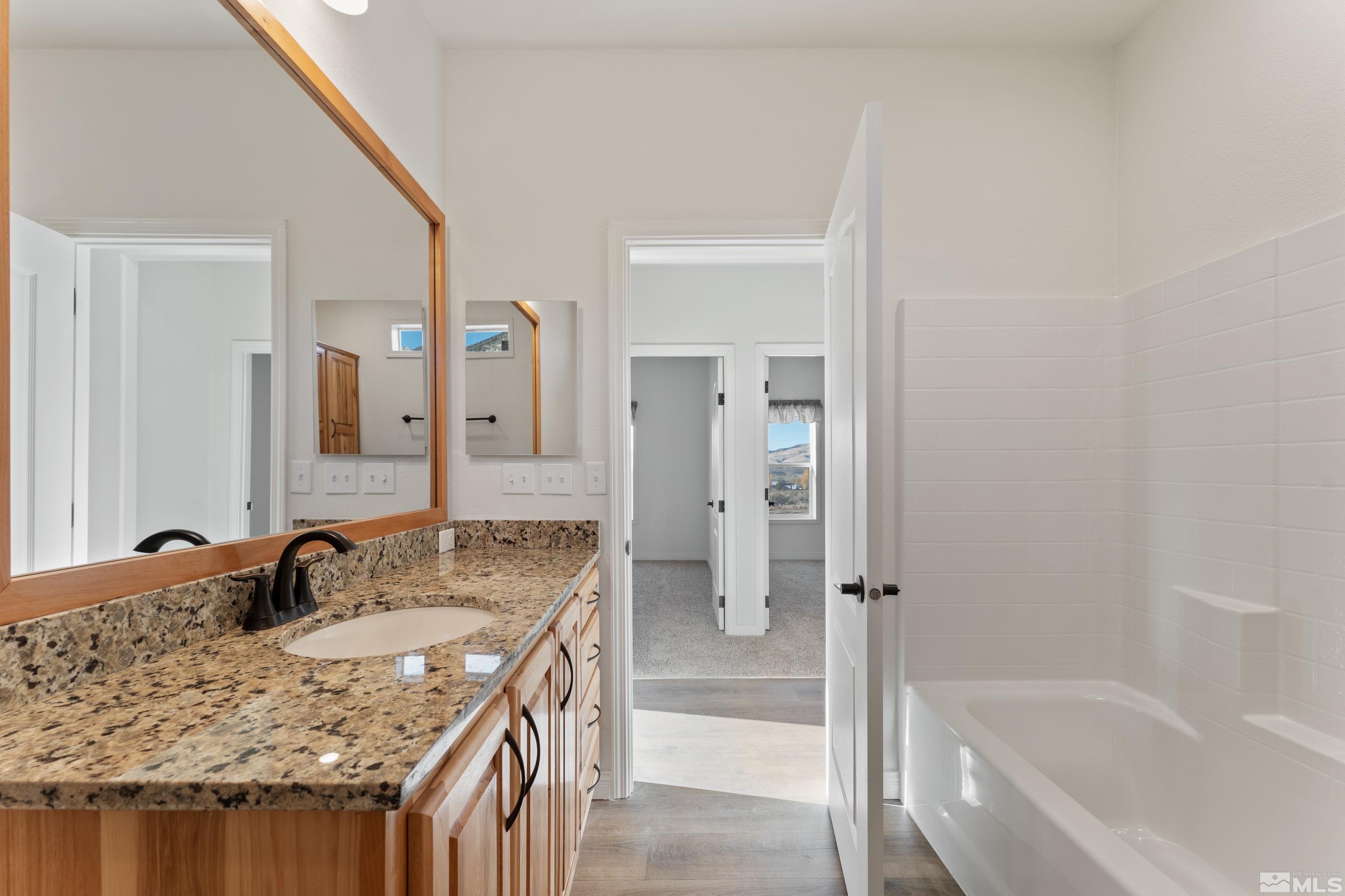 90 Horseshoe Circle Reno, NV 89508 - Photo 30 of 40 a bathroom with a granite countertop tub sink and mirror