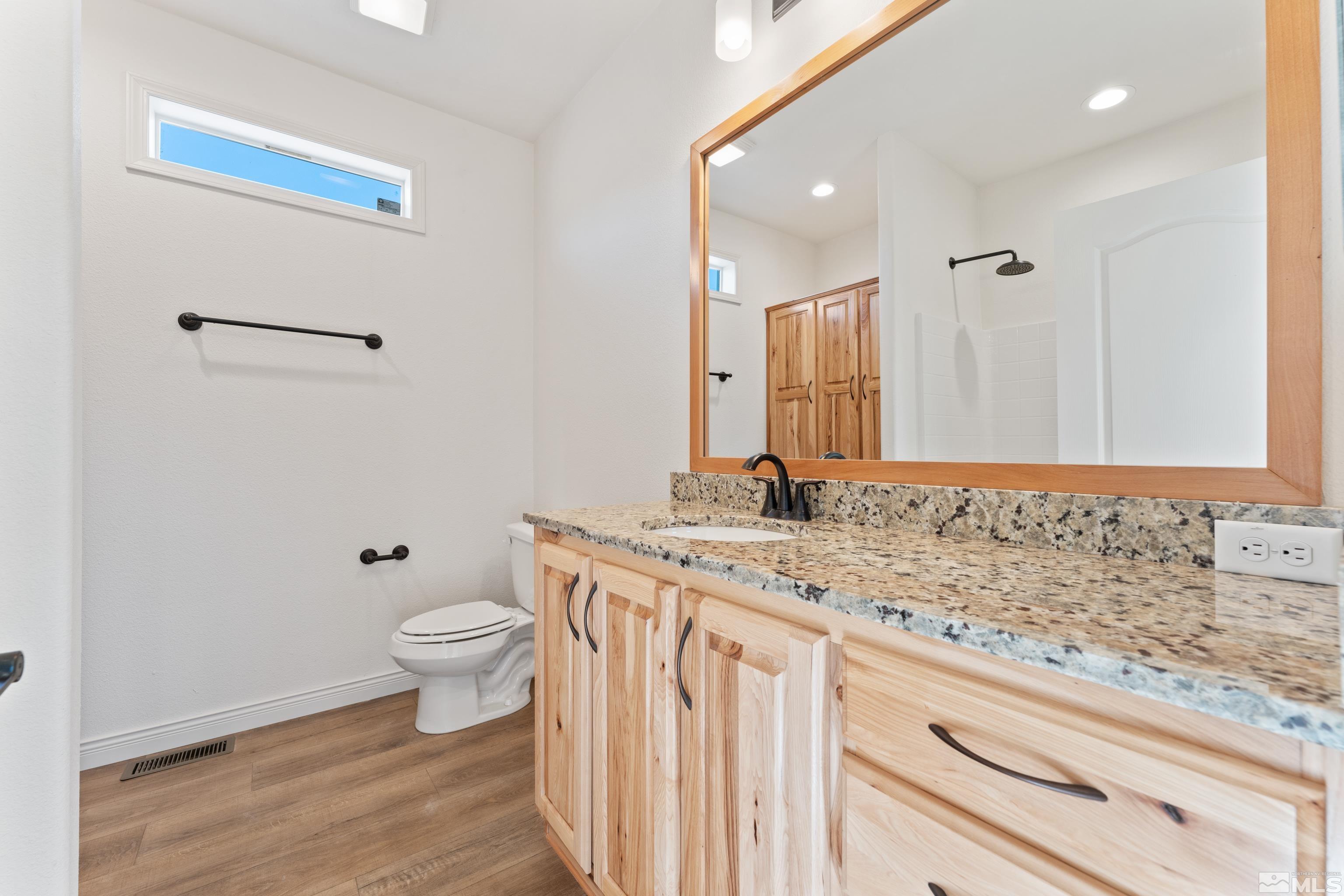 90 Horseshoe Circle Reno, NV 89508 - Photo 31 of 40 a bathroom with a granite countertop sink a toilet and a mirror