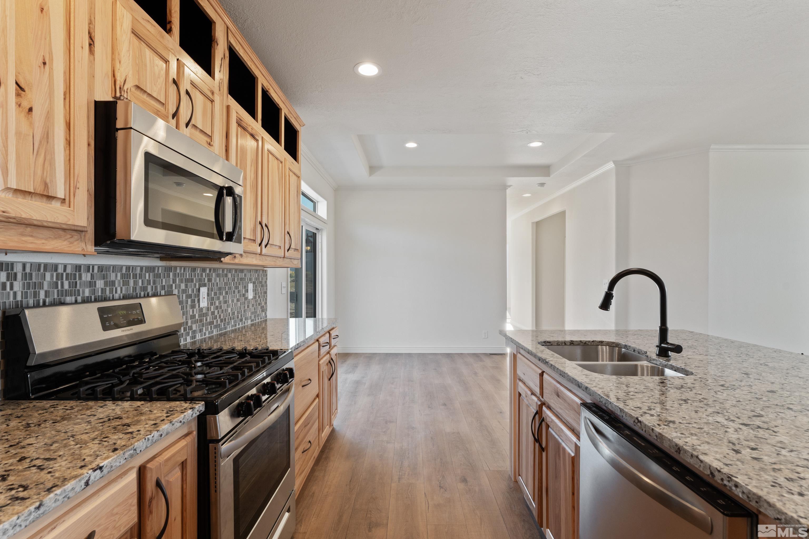 90 Horseshoe Circle Reno, NV 89508 - Photo 8 of 40 a kitchen with granite countertop a stove and a sink