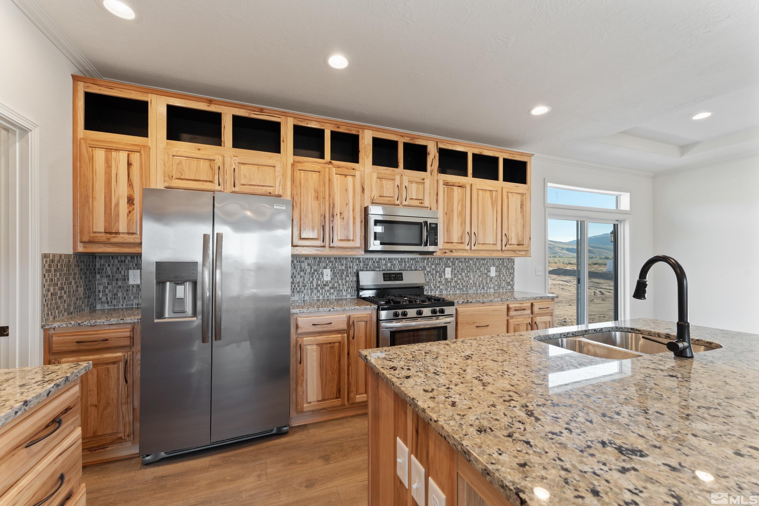 90 Horseshoe Circle Reno, NV 89508 - Photo 9 of 40 a kitchen with stainless steel appliances granite countertop a refrigerator a stove and a sink with wooden floors