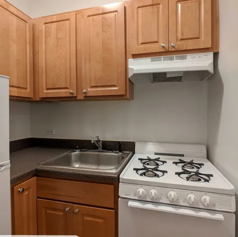 a kitchen with granite countertop a stove and a sink