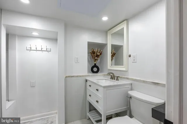 a bathroom with a granite countertop sink a toilet and shower