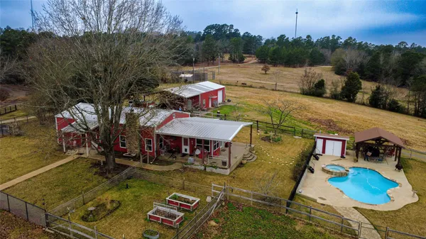an aerial view of a house with swimming pool and a yard