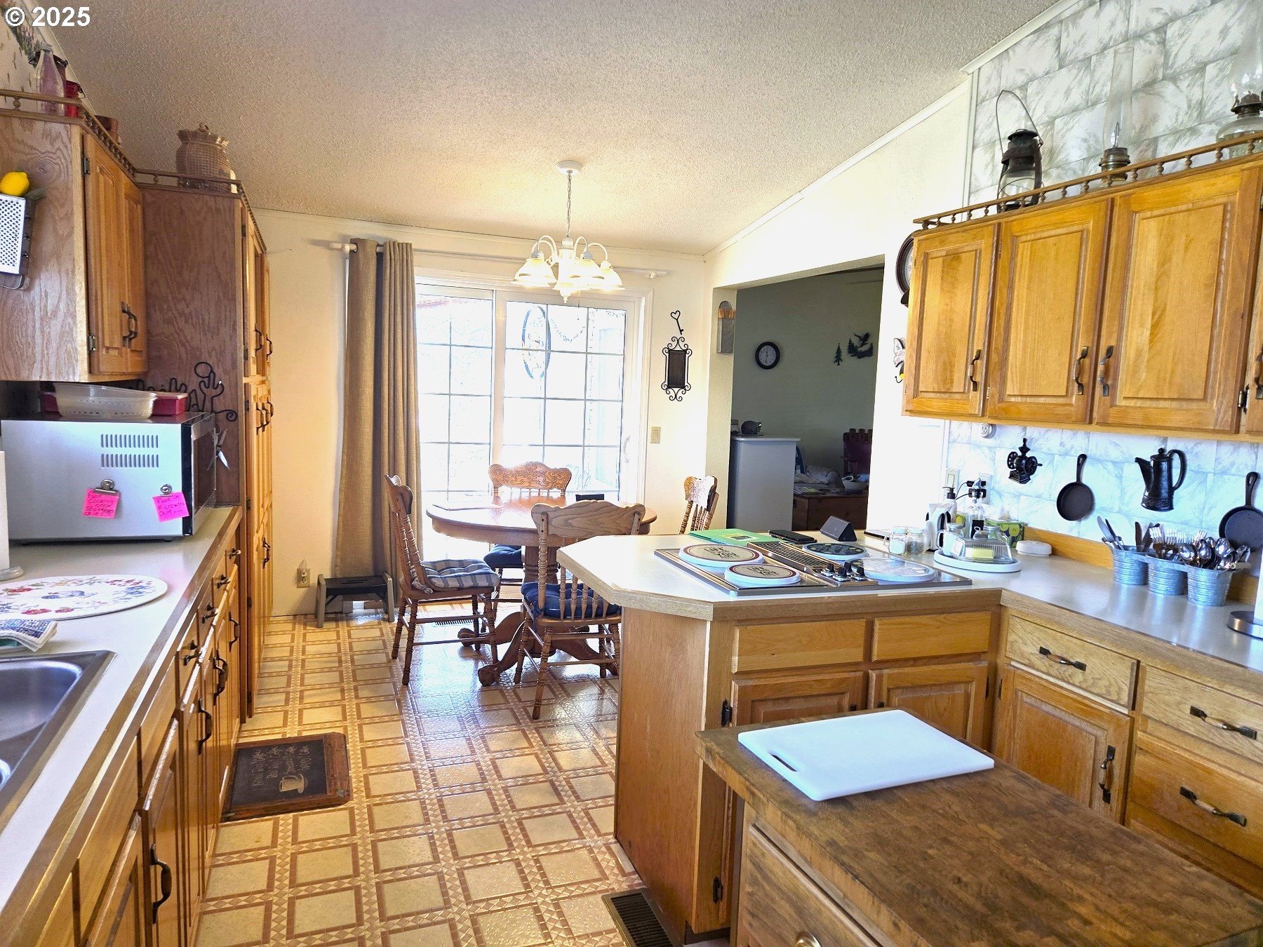 401 Main Street Unity, OR 97884 - Photo 7 of 46 a kitchen with a stove a refrigerator and a dining table with wooden floor