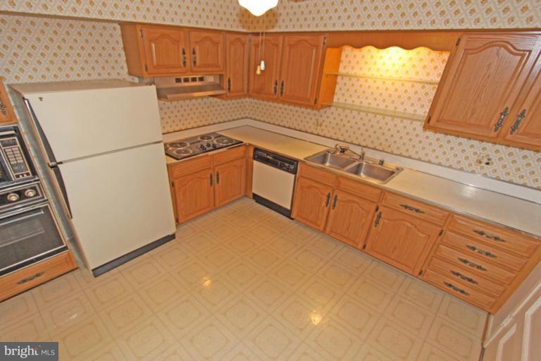 5648 Inverchapel Road Springfield, VA 22151 - Photo 14 of 30 a kitchen with granite countertop white cabinets and white appliances