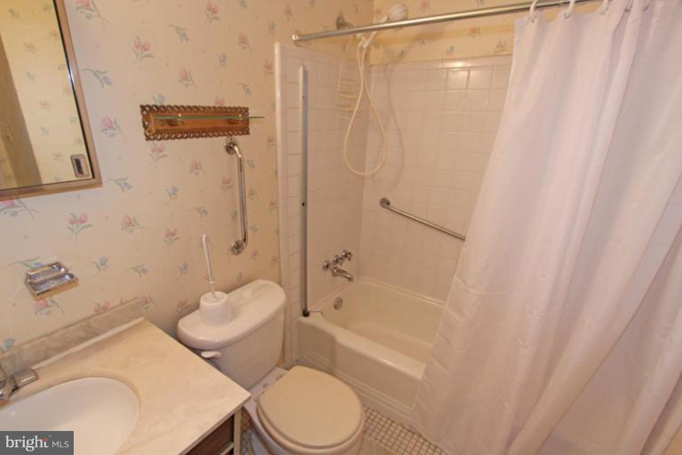 5648 Inverchapel Road Springfield, VA 22151 - Photo 24 of 30 a bathroom with a toilet and a shower curtain