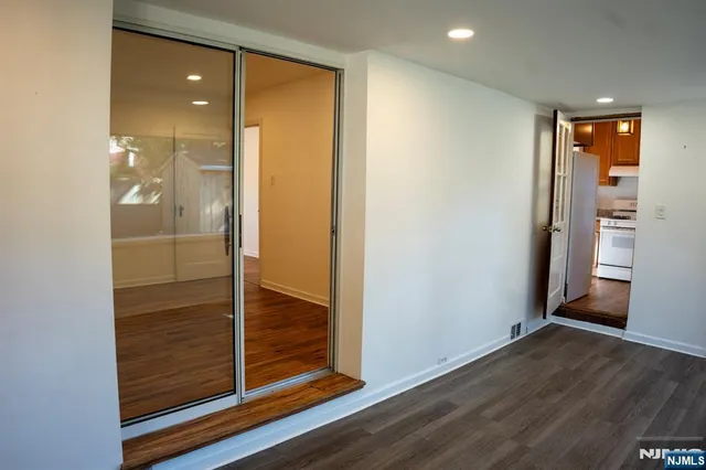 a view of a hallway with wooden floor and closet