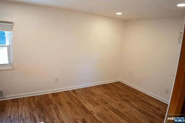 a view of room with wooden floor and fan