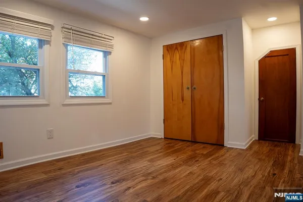 an empty room with wooden floor and a window