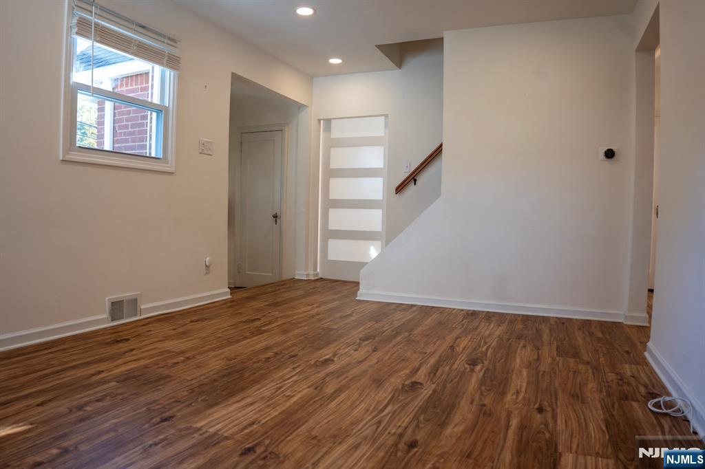 58 Elm Street Dumont, NJ 07628 - Photo 3 of 28 a view of an empty room with wooden floor and a window