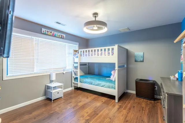 a bedroom with furniture and a wooden floor
