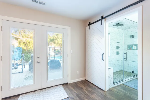 a bathroom with a glass shower door and a window