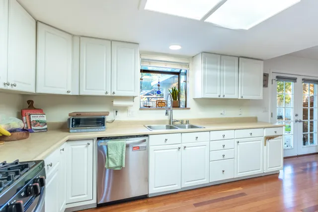 a kitchen with a sink cabinets and wooden floor