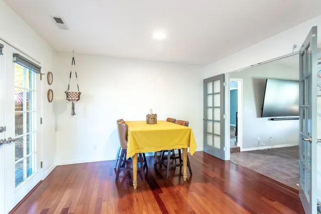 a view of a room with wooden floor table and chairs