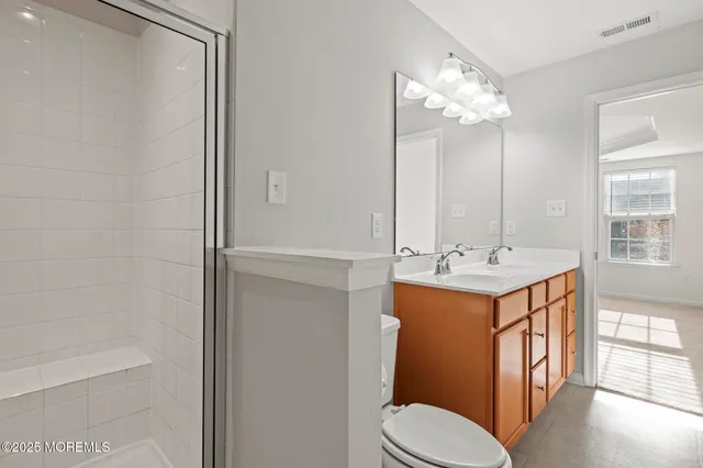 a view of a hallway with closet and a bathroom