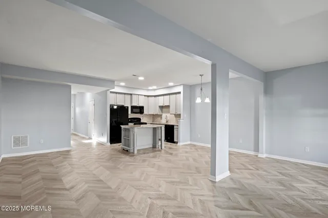 a kitchen with stainless steel appliances granite countertop a kitchen island a stove a refrigerator a sink a counter space and cabinets