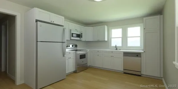 a kitchen with cabinets appliances a sink and a window