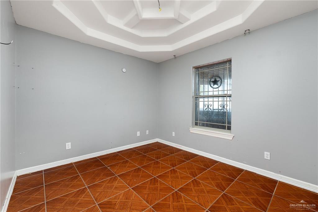 1315 Ruger Street Donna, TX 78537 - Photo 12 of 17 This room features a distinct tray ceiling design and tile flooring laid in a diamond pattern