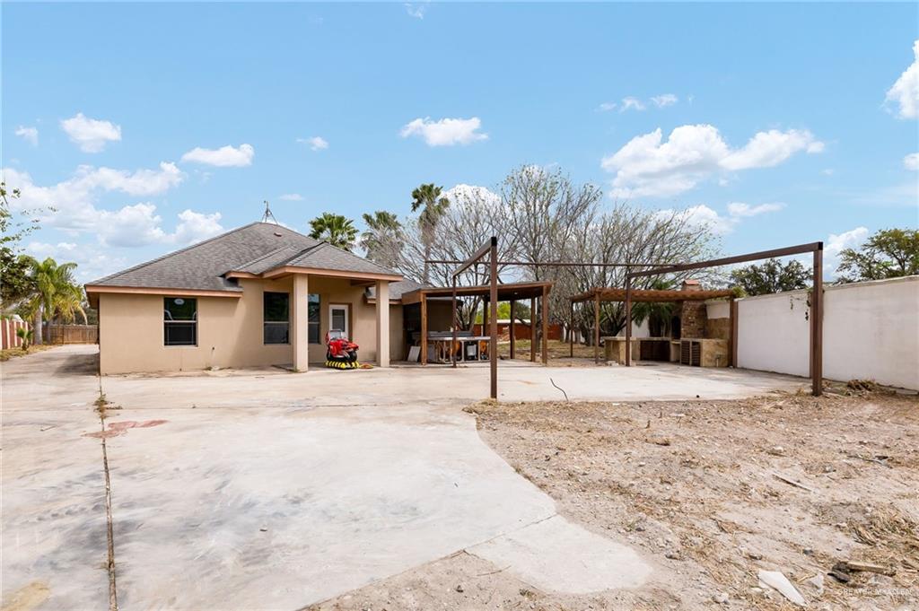 1315 Ruger Street Donna, TX 78537 - Photo 14 of 17 The property features a stucco exterior, an outdoor area with a paved surface, and a covered patio structure