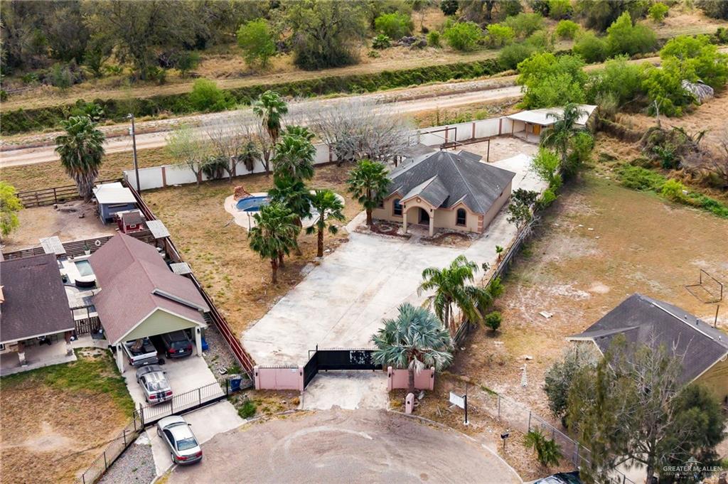 1315 Ruger Street Donna, TX 78537 - Photo 16 of 17 This aerial view highlights the property's expansive lot, featuring a main residence with a covered entrance, a separate structure with a covered carport, and a swimming pool